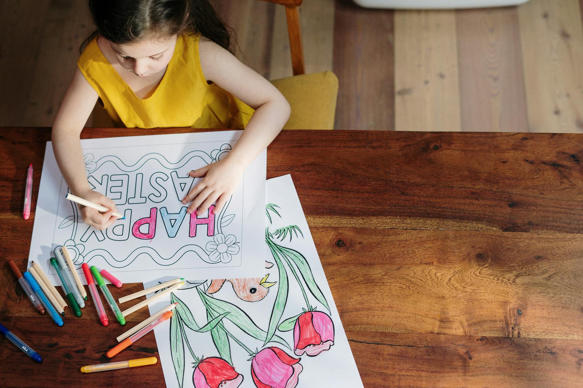 A person coloring in a floral coloring book.