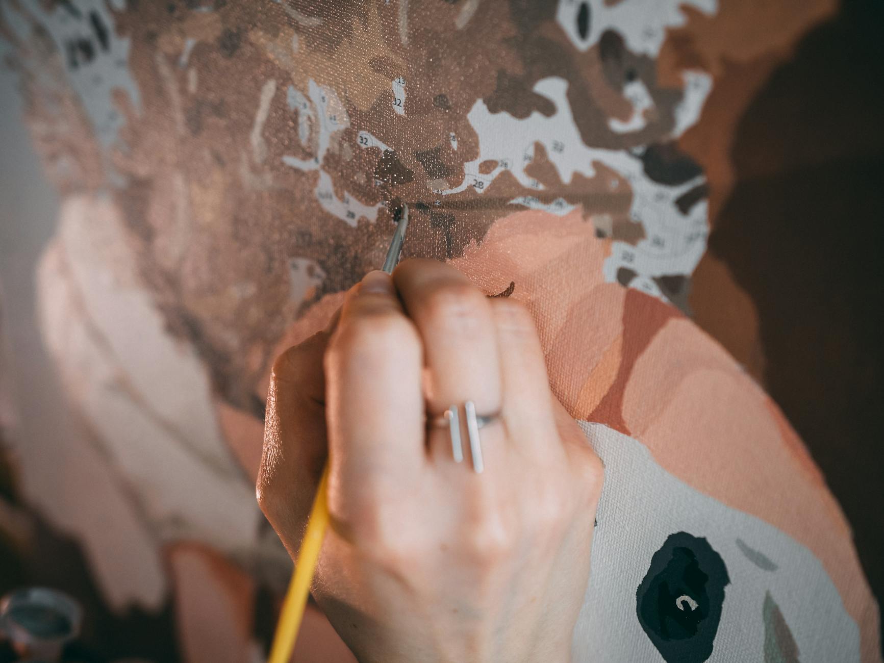 A person's hands coloring in a detailed design with colored pencils.